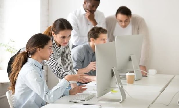 Group of computer technicians collaborating to solve a problem.