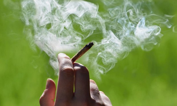 Hand holding a marijuana cigarette