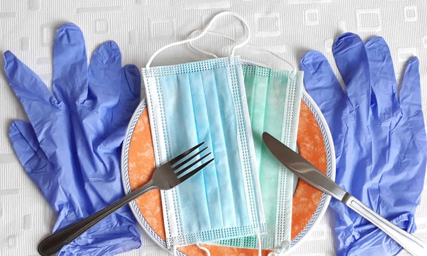 A place setting, as for dining, is depicted with medical gloves and masks integrated into it.
