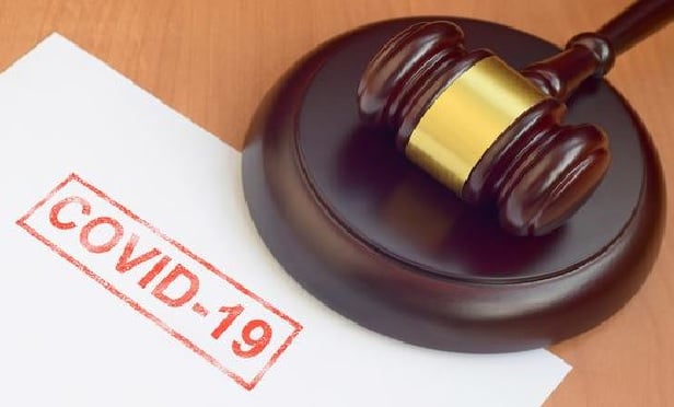 A judge's gavel lies adjacent to the word COVID-19.