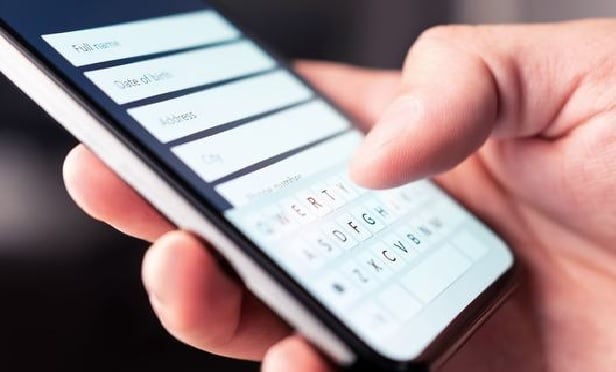 Person holding a phone and using it to pay a bill electronically.