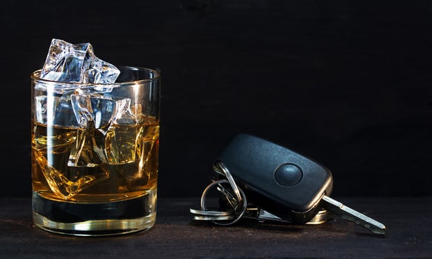 Whiskey glass with ice and car keys.