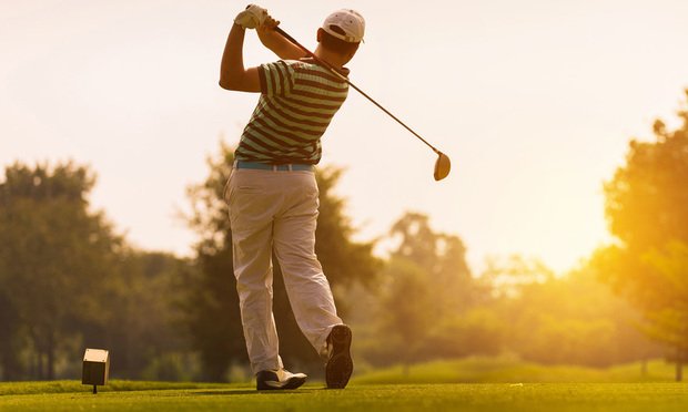 Golfer teeing off.