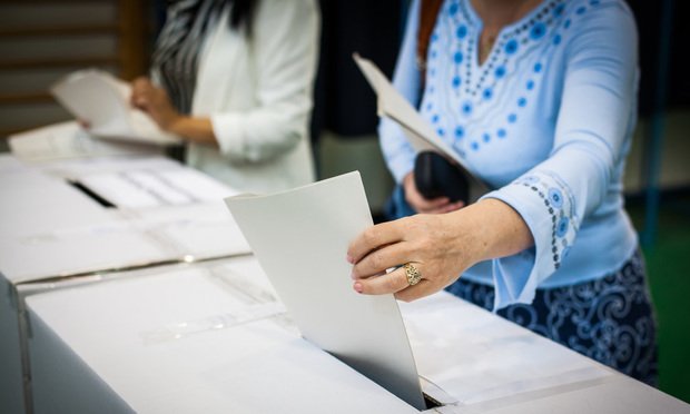 Hand of a person casting a ballot at a polling station during voting. Credit: Alexandru Nika/Shutterstock.com