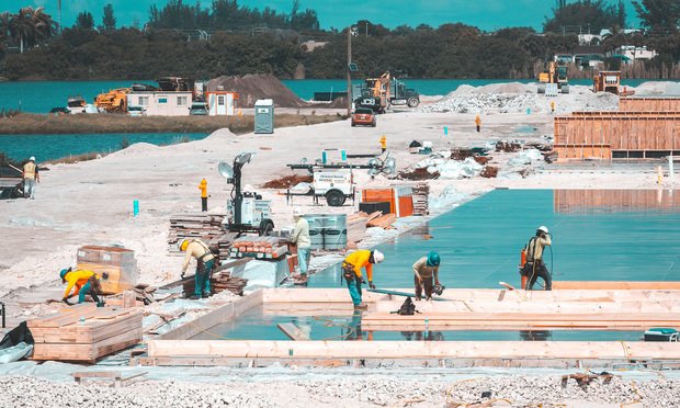 Construction workers make a concrete base, zero cycle pile and strip foundation for industrial building. Fort Lauderdale, Florida, USA - July 29, 2020. Credit: YES Market Media/Shutterstock.com
