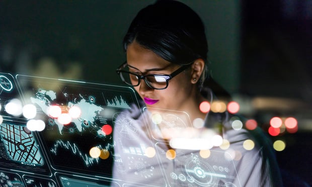 Woman looking at screens with data and charts displayed.
