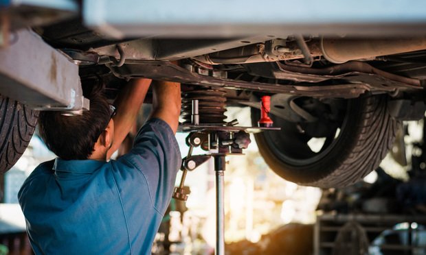 Mechanic repairing a car. Credit: chartphoto/Adobe Stock