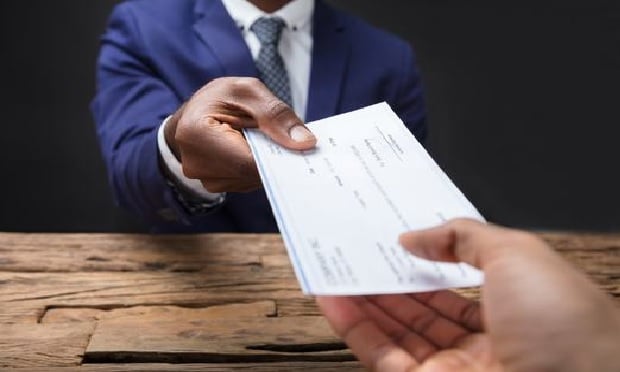One person handing an insurance check to another.