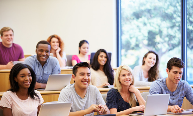 A group of college students sit and listen in a lecture.