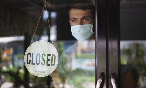 Business owner inside a closed storefront.