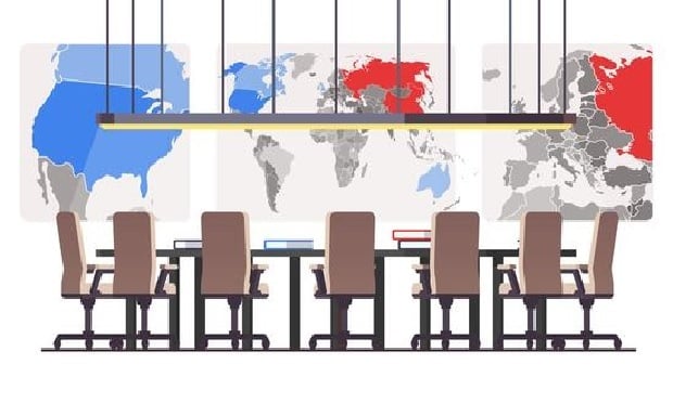 Boardroom with maps on the wall and a table surrounded by empty chairs.