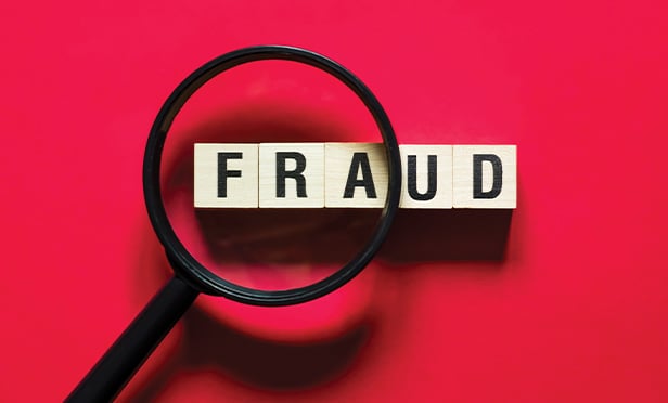 Looking for the word fraud with a magnifying glass.