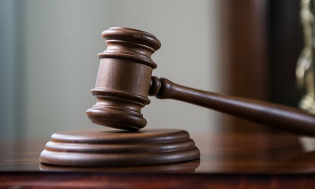 A gavel sits on a desk.