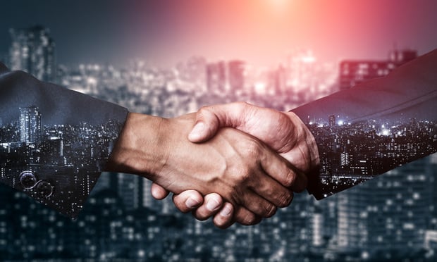 Handshake with city skyline in background. By automating email newsletters and creating new leads with marketing analytics, agents can communicate with clients and prospects in a target and efficient way, freeing up more time to focus on connecting with high-value clients and recommending tailored insurance premiums. (Credit: Blue Planet Studio/Stock.adobe.com) 