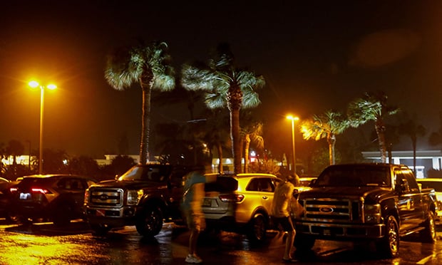 People fight the wind as they walk in a parking lot before Hurricane Nicole makes landfall in Jensen Beach, Florida on November 9, 2022. (Credit: Eva Marie Uzcategui/AFP/Getty Images)