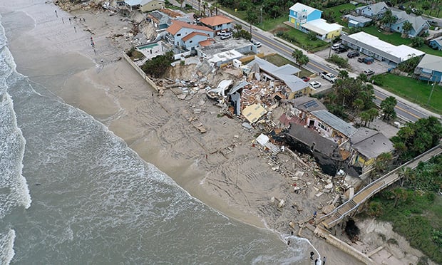 Homes are partially toppled onto the beach after Hurricane Nicole came ashore on November 10, 2022, in Daytona Beach, Florida. (Credit: Joe Raedle/Bloomberg)