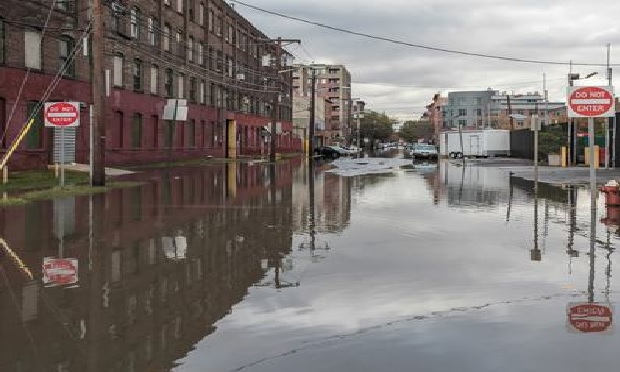 Flooded street with water-damaged buildings.