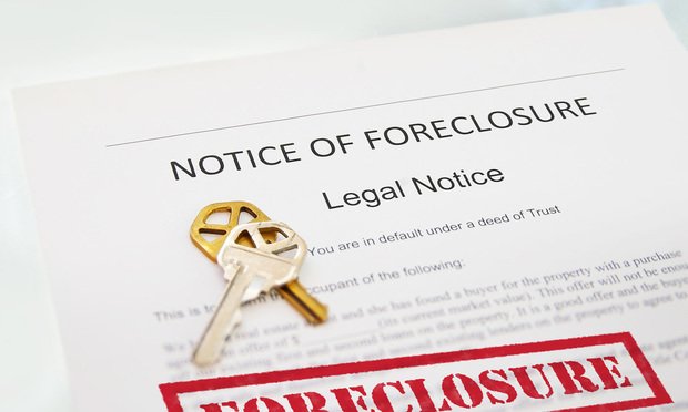 A notice of foreclosure with a set of keys on top of it.