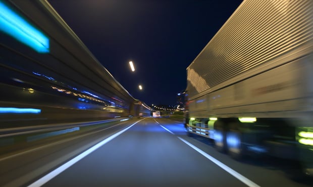 A tractor-trailer on a highway at night