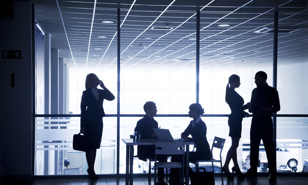 Business people shown in silhouette in an office
