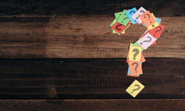 A question mark formed out of smaller slips of paper with question marks on them.