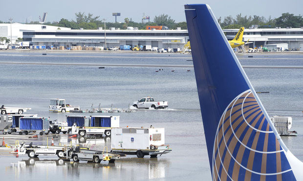 A truck drives on the flooded runway at Fort Lauderdale- Hollywood International Airport, Thursday, April 13, 2023, in Fort Lauderdale, Fla. Fort Lauderdale issued a state of emergency as flood conditions continued through many areas.