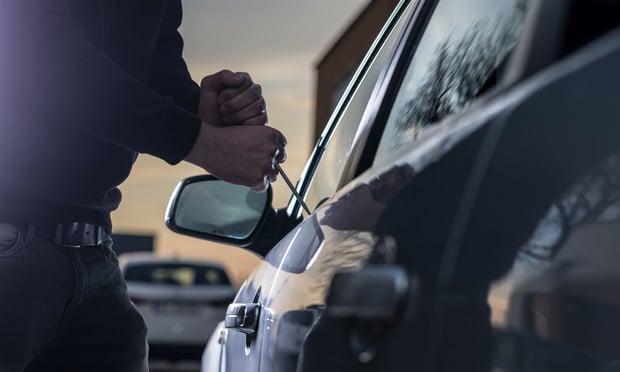 A thief attempts to break into a car