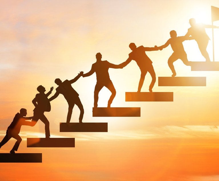 A group of people helping each other up a series of steps