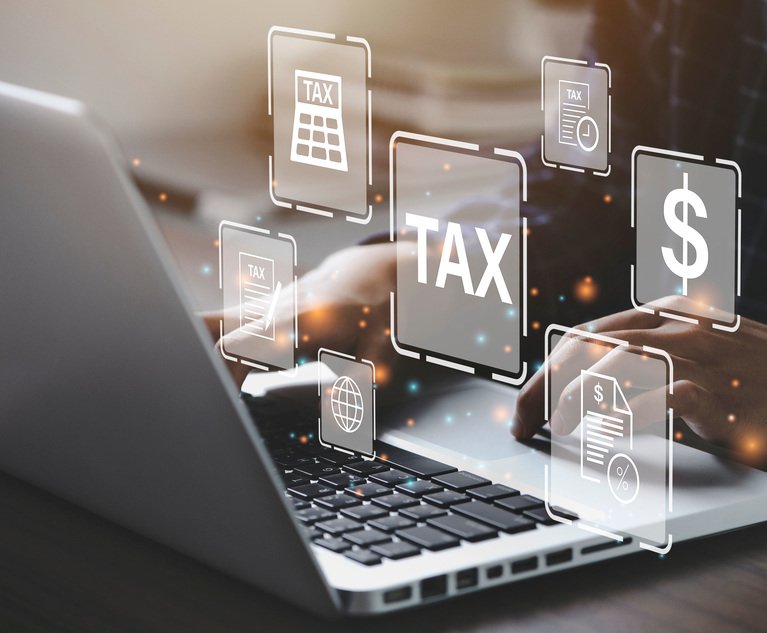 A person's hands on the keyboard of a laptop as tax-related graphics float around them.
