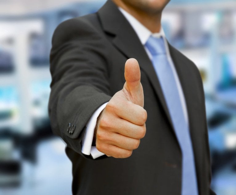 A person holds a 'thumbs up' to the camera.