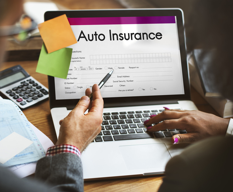 A person fills out an auto insurance form on a laptop.