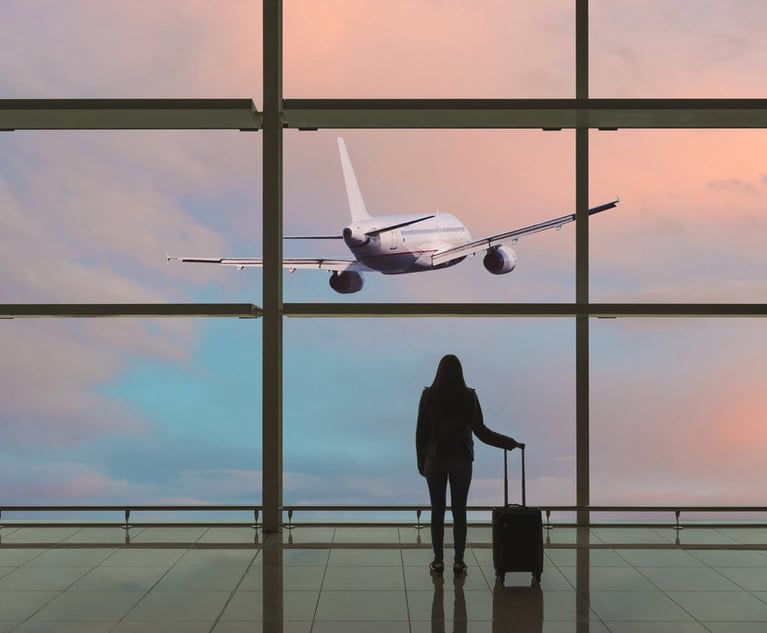 Woman in airport watches her plane takeoff without her. 