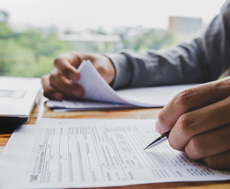 Closeup of man hand filling income tax forms. 