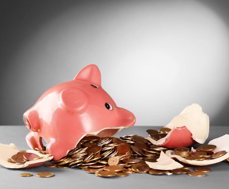 A smashed piggy bank with coins falling out of it.