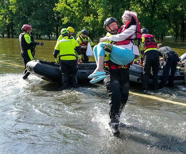 A firefighter carries a resident evacuated in a boat from her flooded home in the aftermath of a severe storm in Conroe, Texas, on Thursday, May 2, 2024. Credit: Brett Coomer/Houston Chronicle/Getty Images