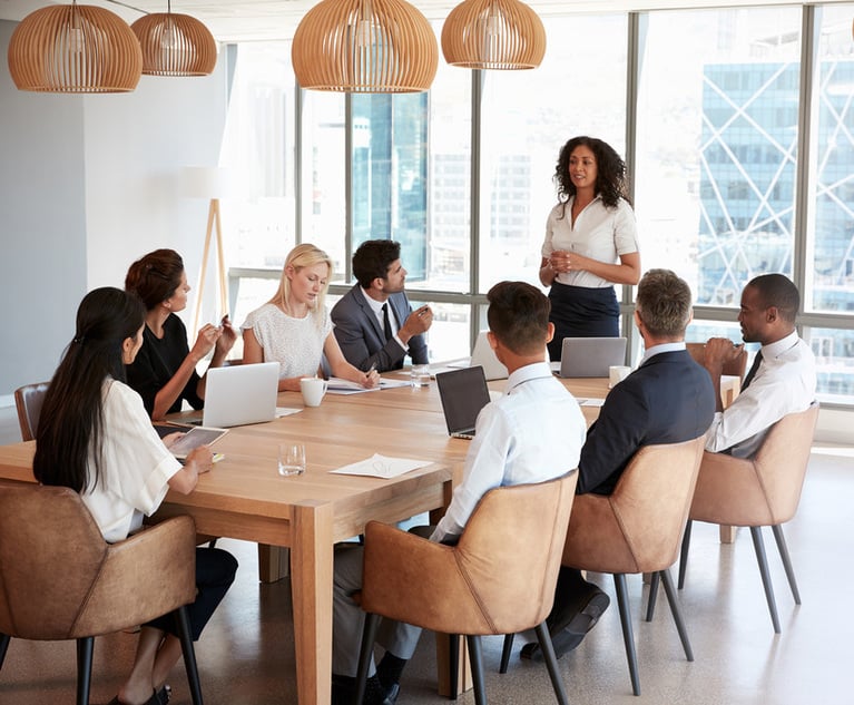 A group of young professionals sitting around a table during a business meeting.