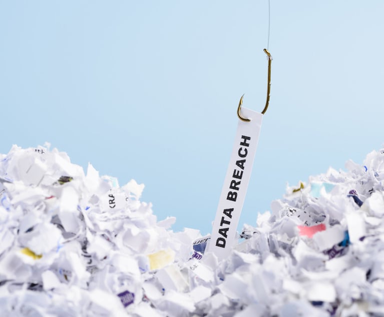 A fishing hook pulls a slip of paper that says "data breach" out of a pile of other paper scraps.