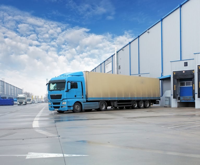 Unloading cargo truck at warehouse building.