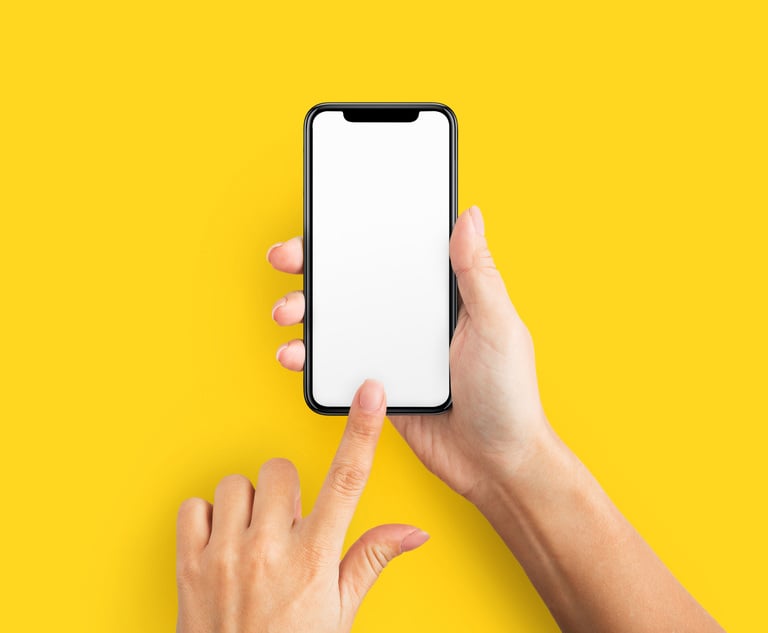 A person holding an iphone with a blank screen against a yellow background