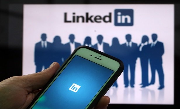 The LinkedIn Corp. logo is displayed on the screens of an Apple Inc. iPhone 6 and a laptop in this arranged photograph taken in London, U.K., on Friday, May, 15, 2015. Facebook Inc. reached a deal with New York Times Co. and eight other media outlets to post stories directly to the social network's mobile news feeds, as publishers strive for new ways to expand their reach. Photographer: Chris Ratcliffe/Bloomberg