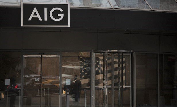 A security guard stands inside the American International Group Inc. (AIG) headquarters office in New York, U.S., on Tuesday, Jan. 29, 2016. American International Group Inc., the insurer being pressured by activist investor Carl Icahn to divest assets, had the outlook on its credit rating changed to negative from stable by Standard & Poor's after announcing plans to sell a stake in mortgage insurer United Guaranty Corp. Photographer: Victor J. Blue/Bloomberg