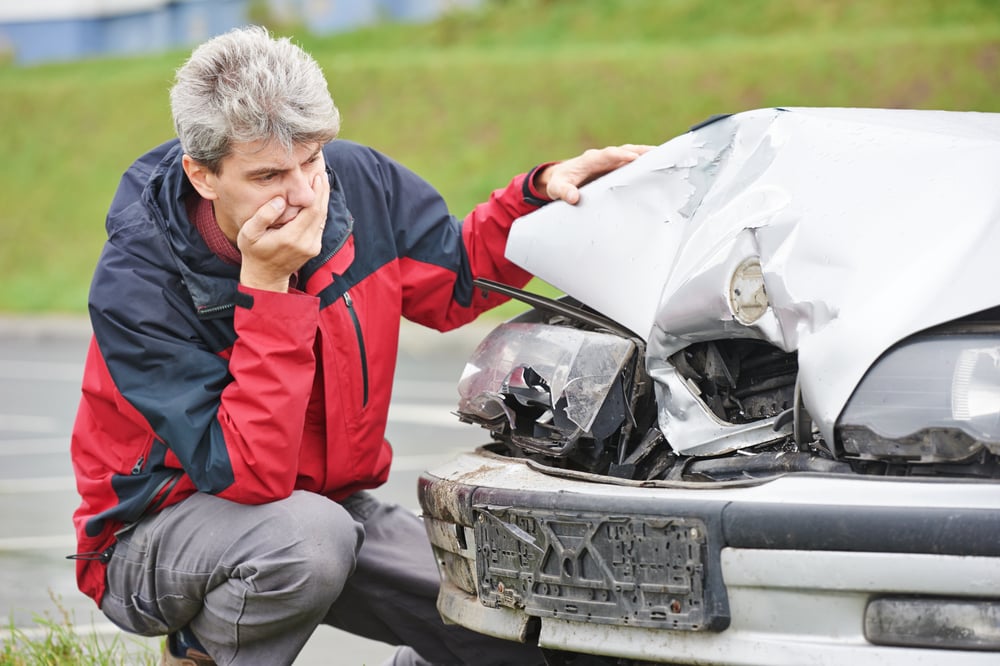 Man looking at damaged car