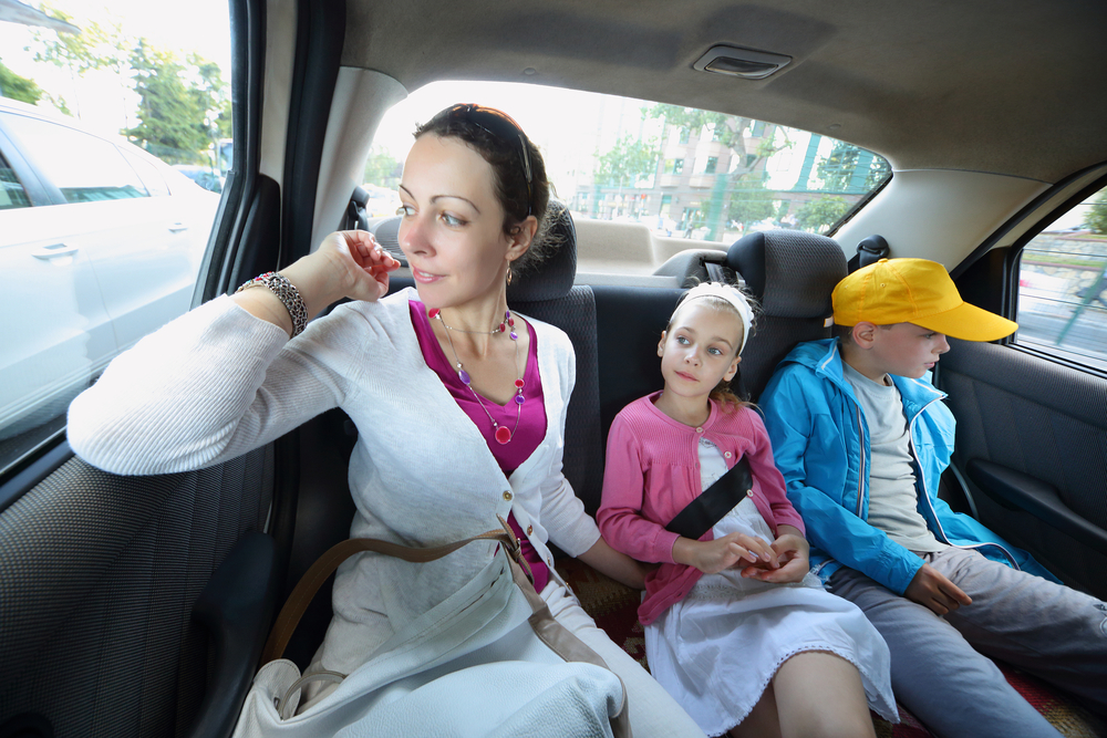 Woman and children in back seat of car