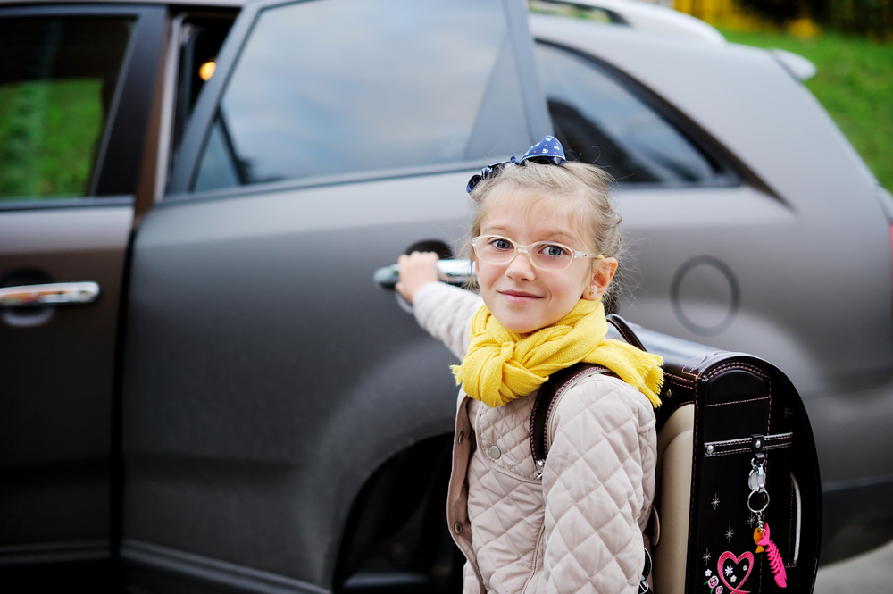 Child getting into back seat of car