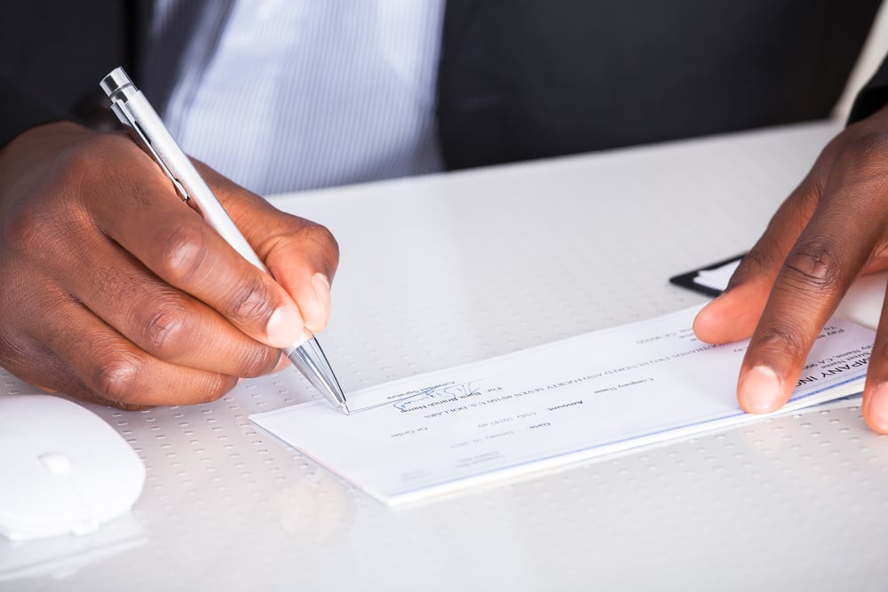 Man's hands writing check