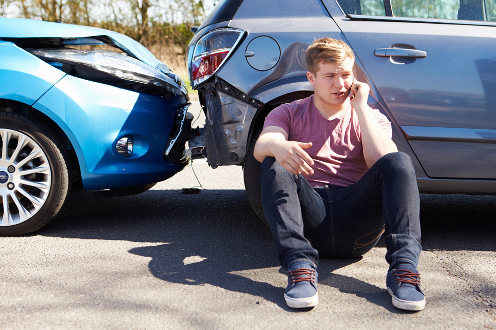 man making phone call after traffic accident