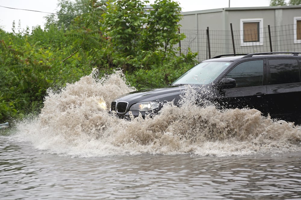 SUV driving through a flooded street