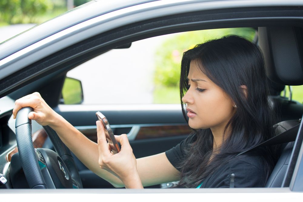 Woman texting while driving a car