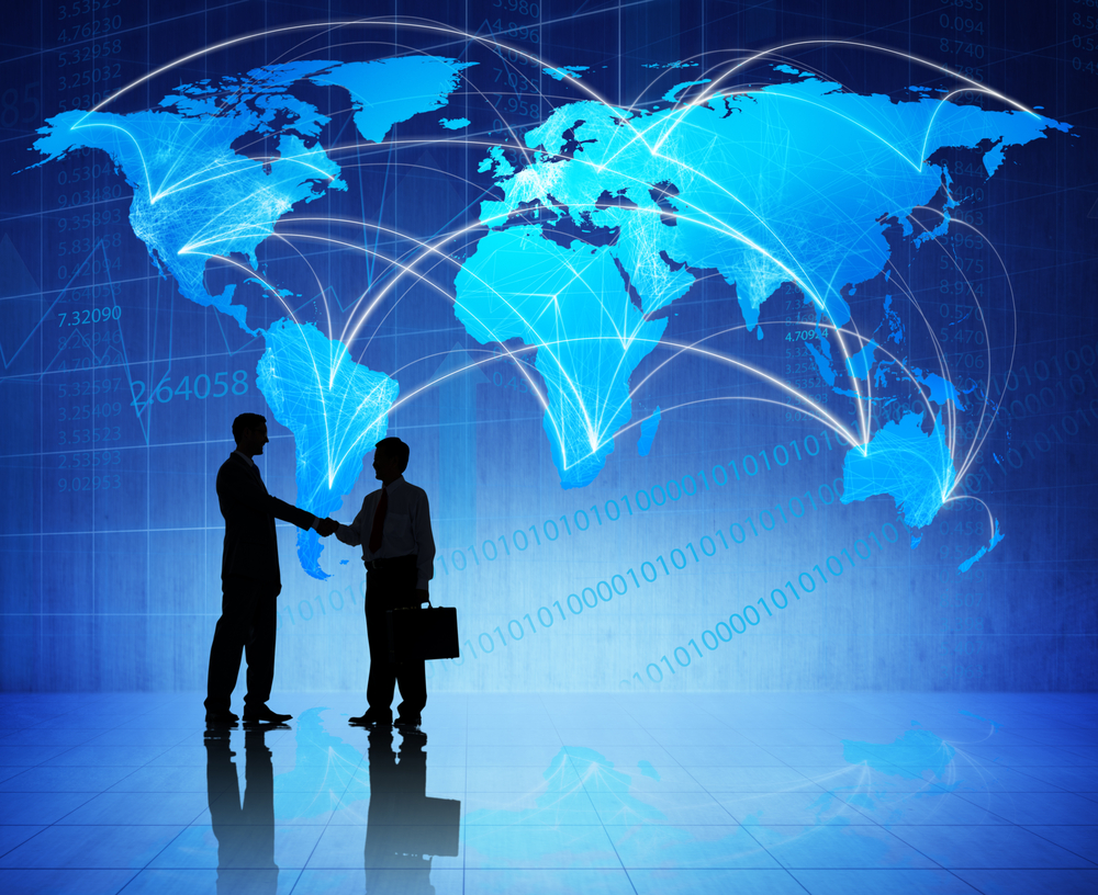 Two men shaking hands in front of a world map