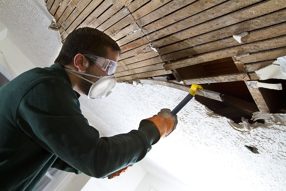 man making house ceiling repairs